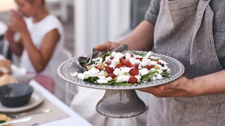 På bordet står et kakefat fra PotteryJo på bordet hvor det serveres en nydelig sommerlig salat laget med jordbær og fetaost.