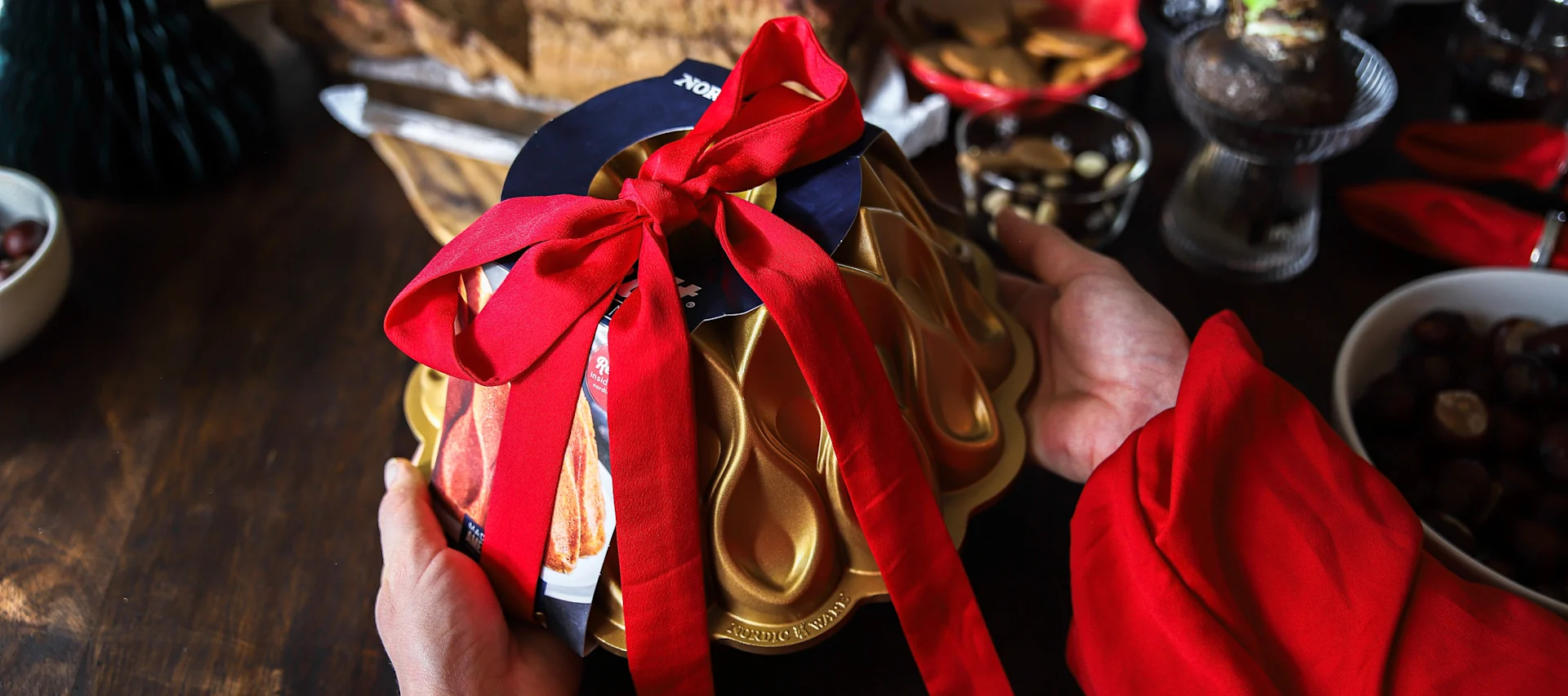 En bakeform fra Nordic Ware med et rødt, knyttet bånd rundt – et tips til julegave.