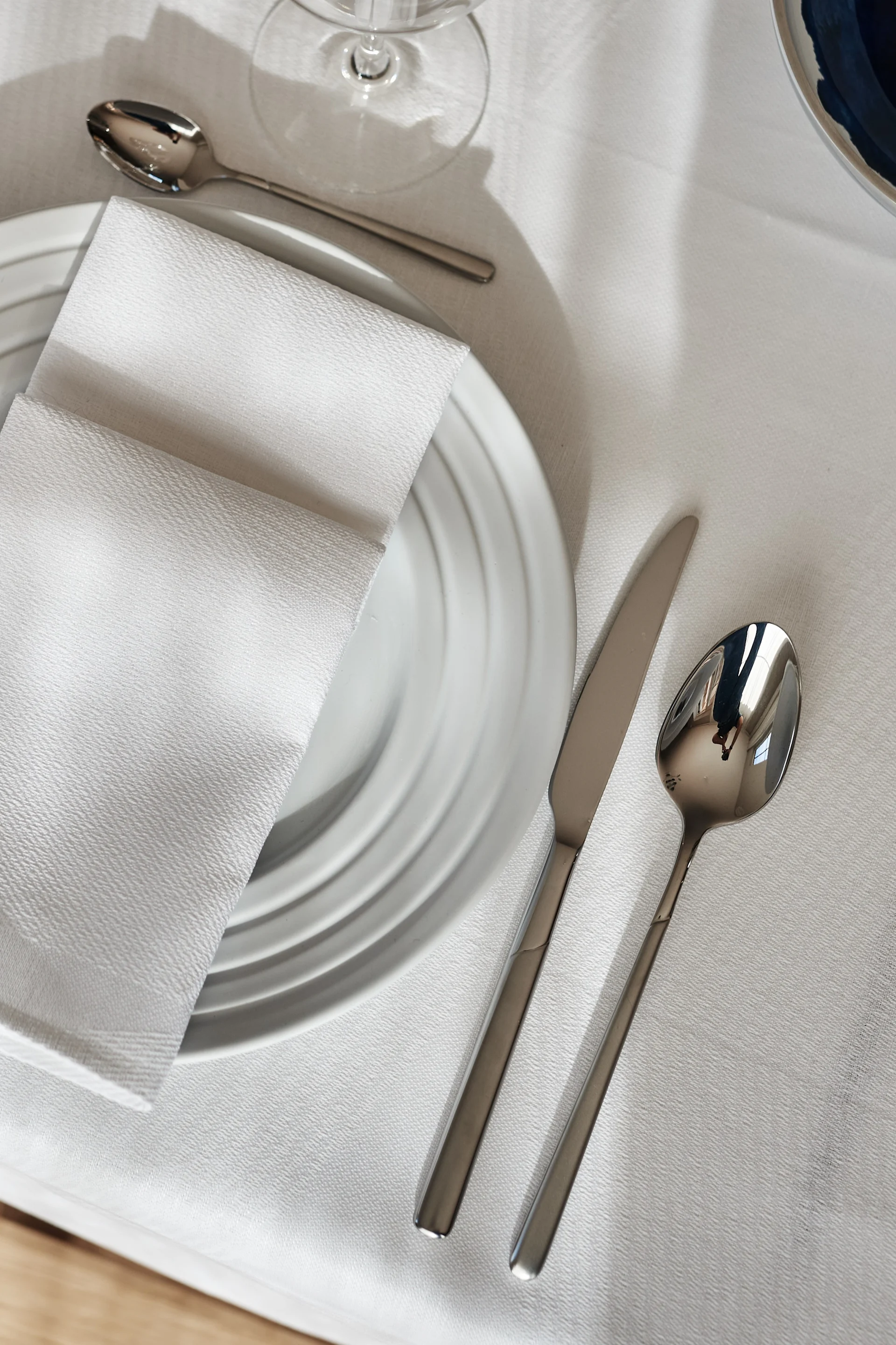 Bestikkguide - vedlikeholdsråd for rengjøring av bestikk. Frostbestikk fra Scandi Living ved siden av hvit Lines tallerken, Geometric linserviett og Geometric linduk fra NJRD.