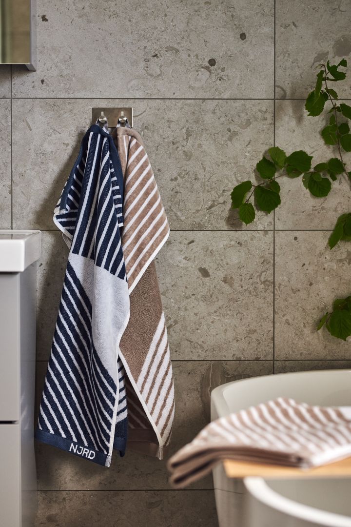 Lag et hjemmespa på badet ved å innrede med Stripes myke håndklær fra NJRD i beige og blått for avslappende stunder.