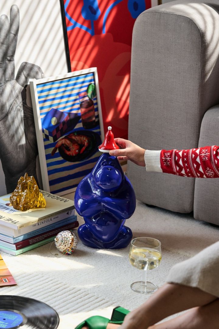 En hånd plasserer nisseluen fra Kay Bojesen på hodet til Gabba Gabba fra Kosta Boda, det perfekte tillegget til vår vintage julepynt.