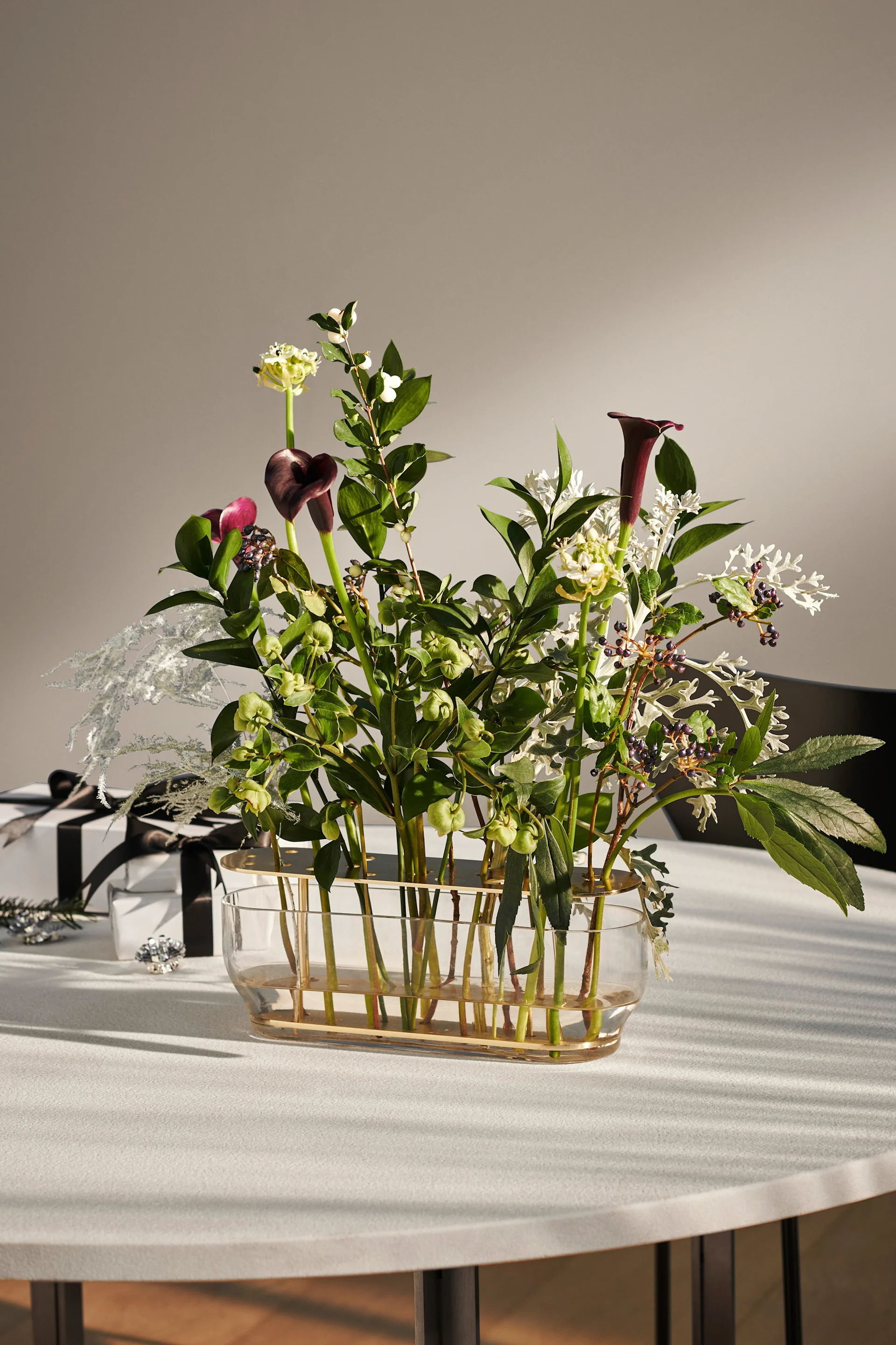 På et spisebord står Ikebana-vasen fra Fritz Hansen, der enkeltstilker får stå i fokus.