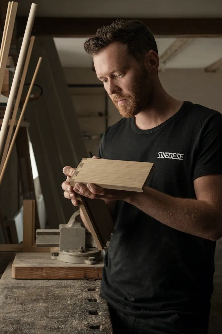 En mann som lager møbler i Swedese møbelfabrikk i Sverige.