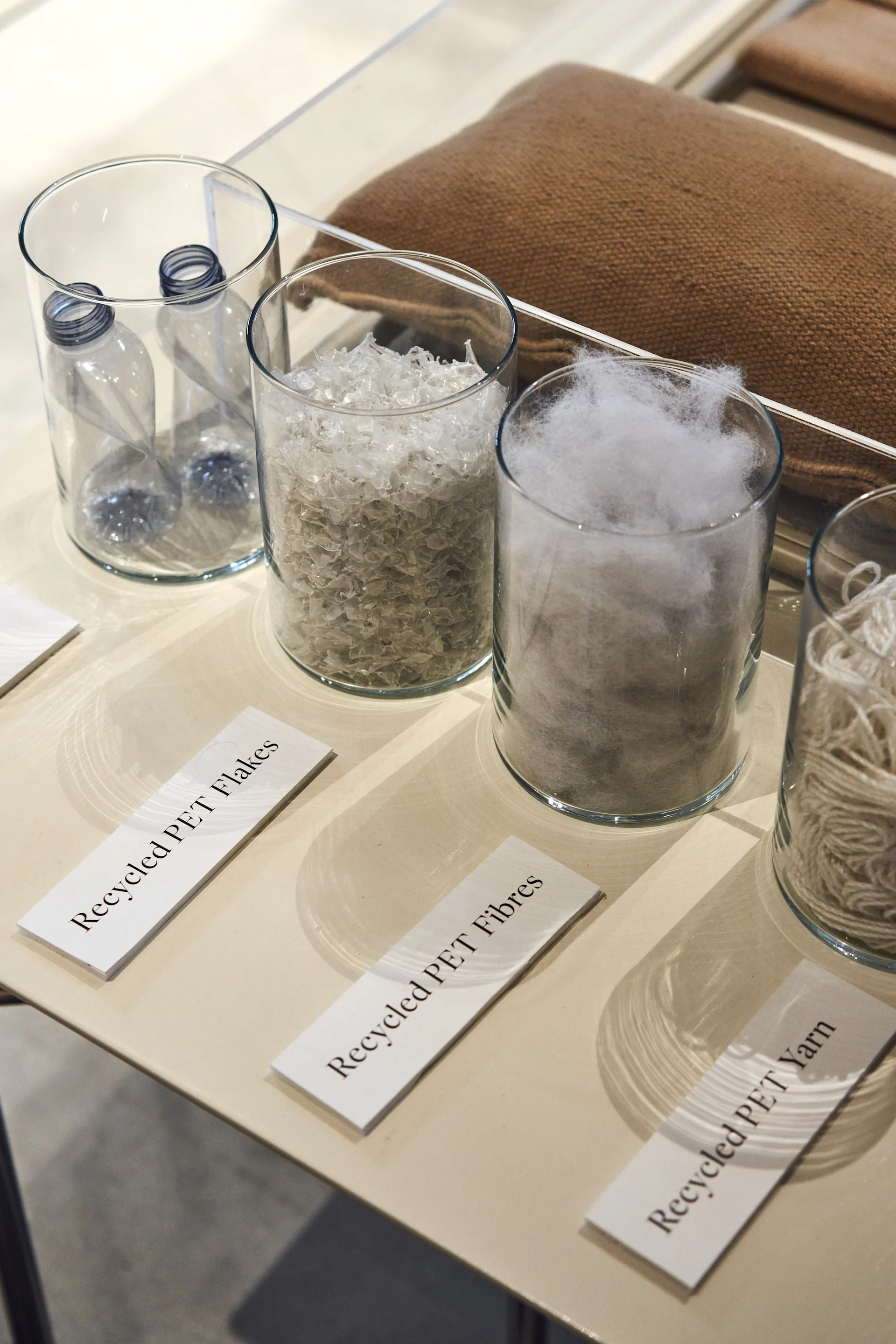 Glassbeholdere som viser resirkulerbare materialer i Ferm Livings showroom.