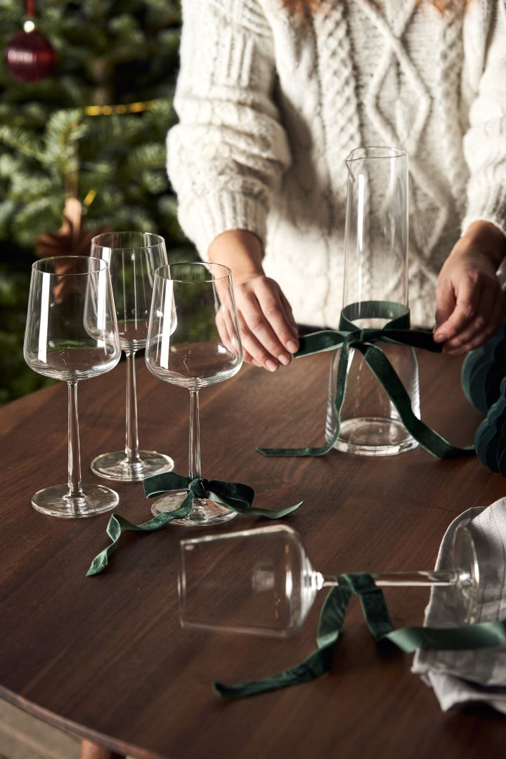 Essence vinglassene fra Iittala er den perfekte julegaven, her ser du det innpakket i grønt bånd.
