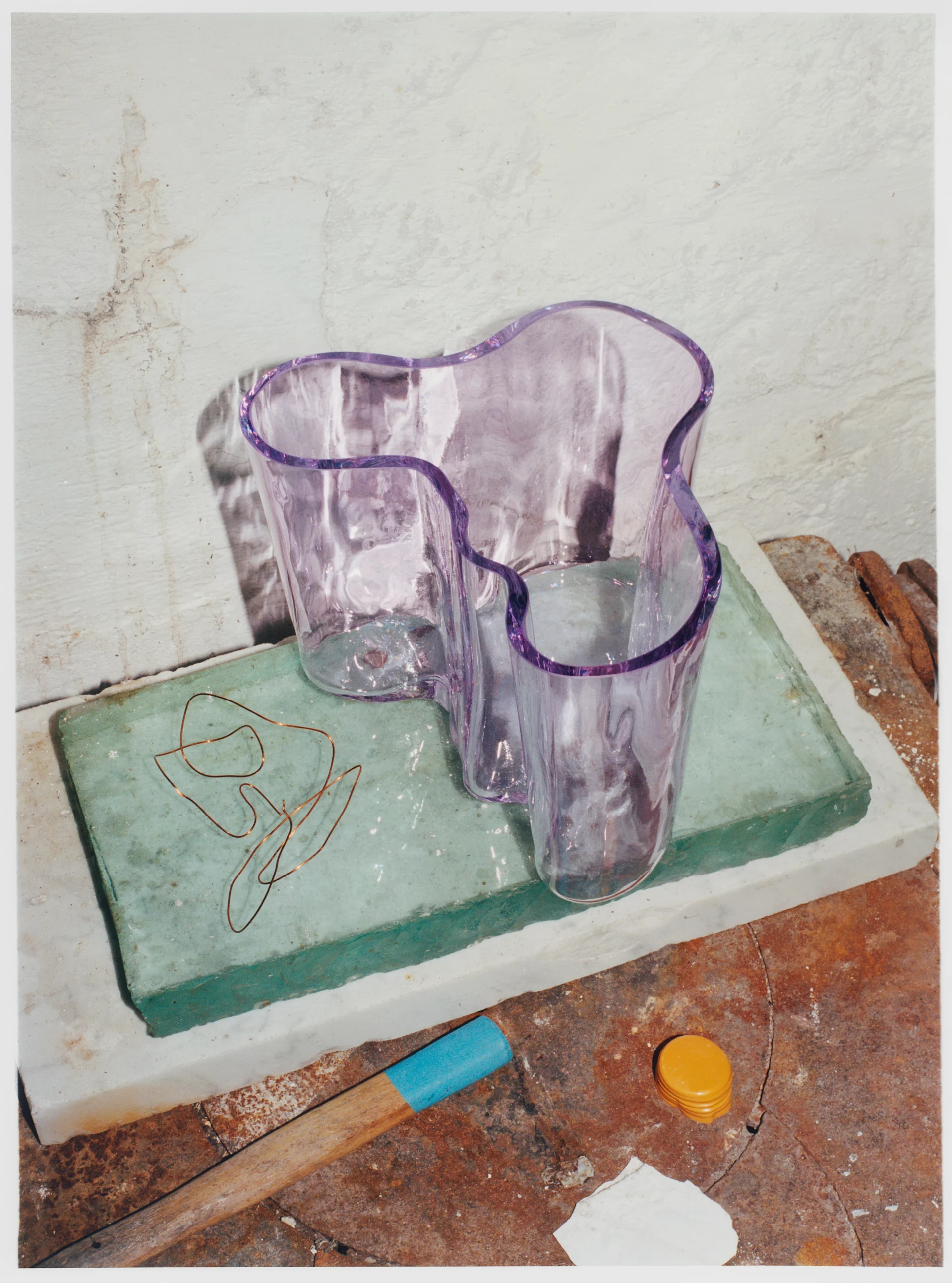 Alvar Aalto-vase fra Iittala i en lys lilla farge stående på steinblokker.