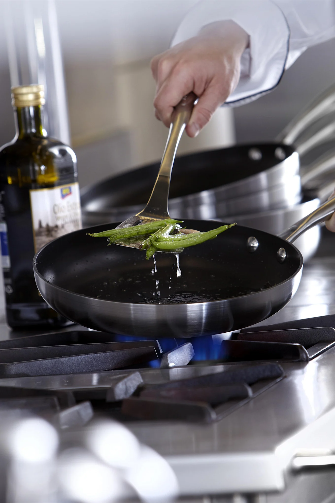 Norden støpejernsstekepannen fra Fiskars på et bord med kjøttboller og serveringsskje av tre, julegavetips for matelskere.