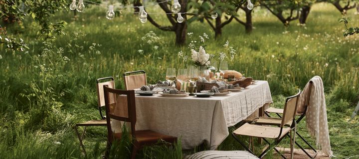 Skap en borddekking til sommerfesten i hagen med komfortable møbler, myke tekstiler, fargerikt servise og en lysslynge som øker hyggefaktoren.