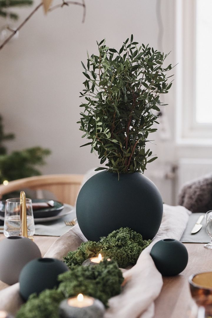 Grønn, rund vase fra Cooee Design pynter julebordet, som går i grønne toner med inspirasjon henter fra naturen.