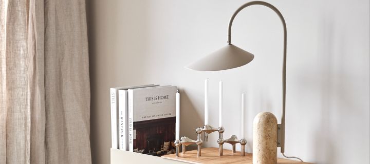 Forny hjemmet ditt med moderne lamper - her Arum bordlampe fra Ferm Living i toner av beige og marmor ved siden av Stoff Nagel lysestake i sølv.