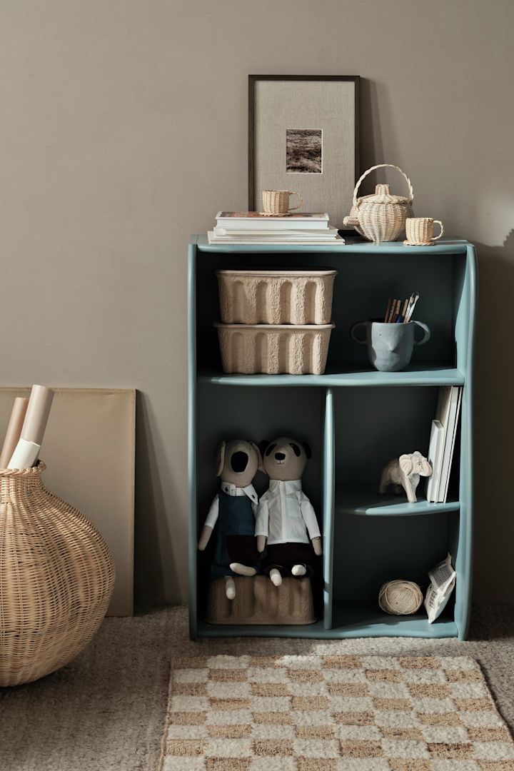 En liten bokhylle som rommer mye, Slope bokhylle i den blå fargen storm fra Ferm Living, har fire hyller i ulike størrelser. Dette gjør den perfekt for både bøker, bokser og leker.