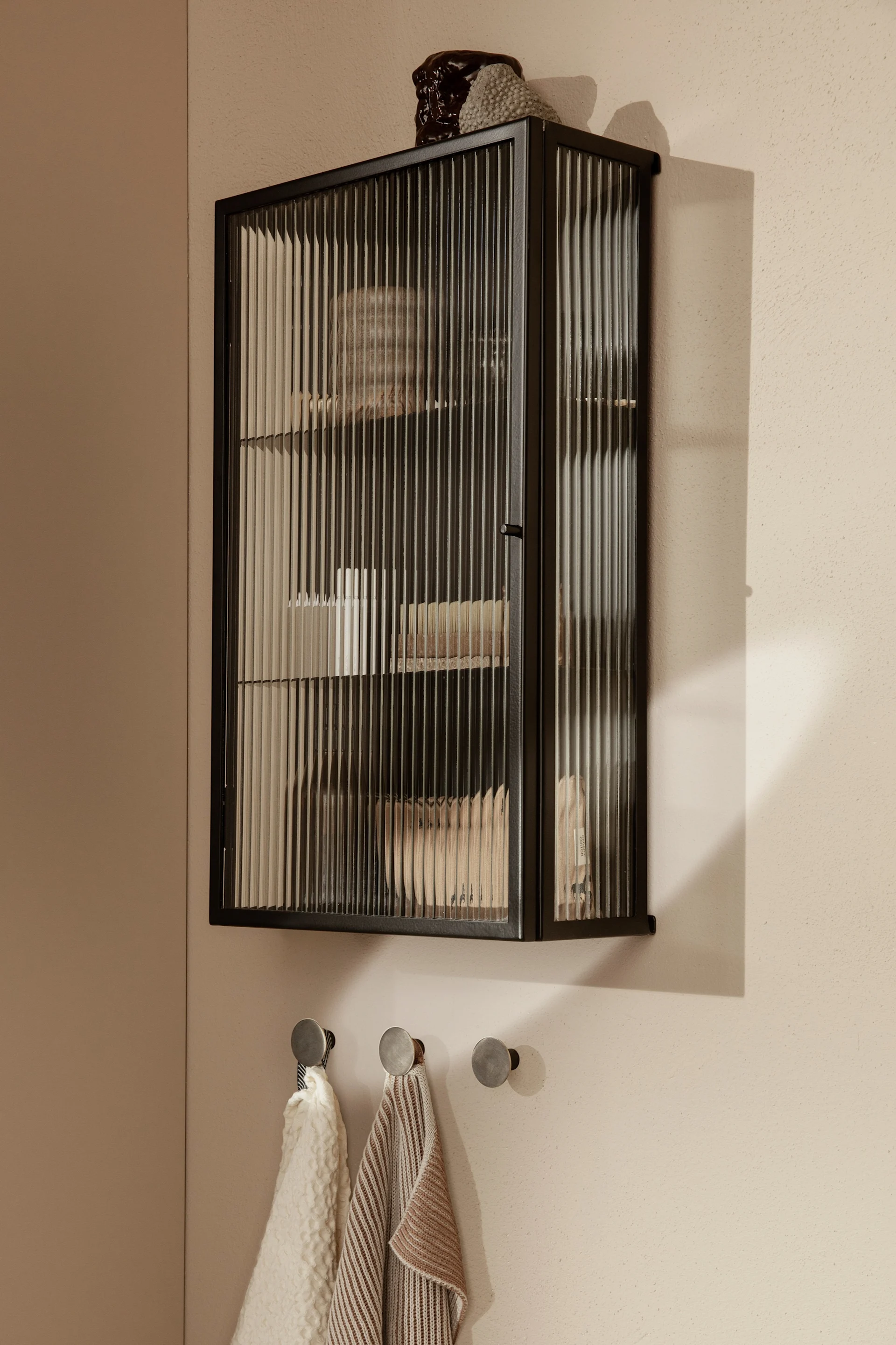 Interiør i riflet glass er en av årets trender, der Haze veggskap fra ferm LIVING er en stor favoritt på badet for oppbevaring av skjønnhetsprodukter.