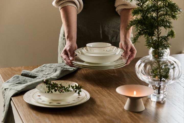 Pynt med granbar i borddekkingen, i for eksempel en vase, på tallerkenen eller i servietten for å skape julestemning i hjemmet.