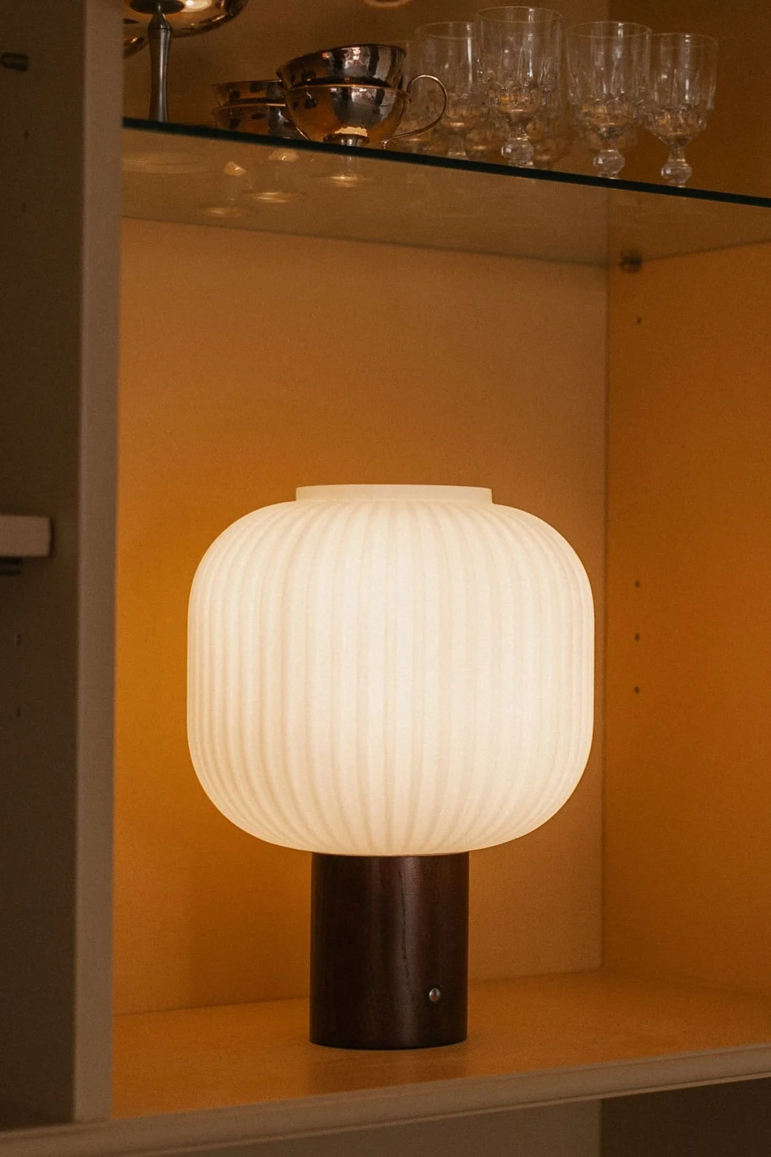 E27 lampe fra Muuto med pære med 2500K på et sidebord.