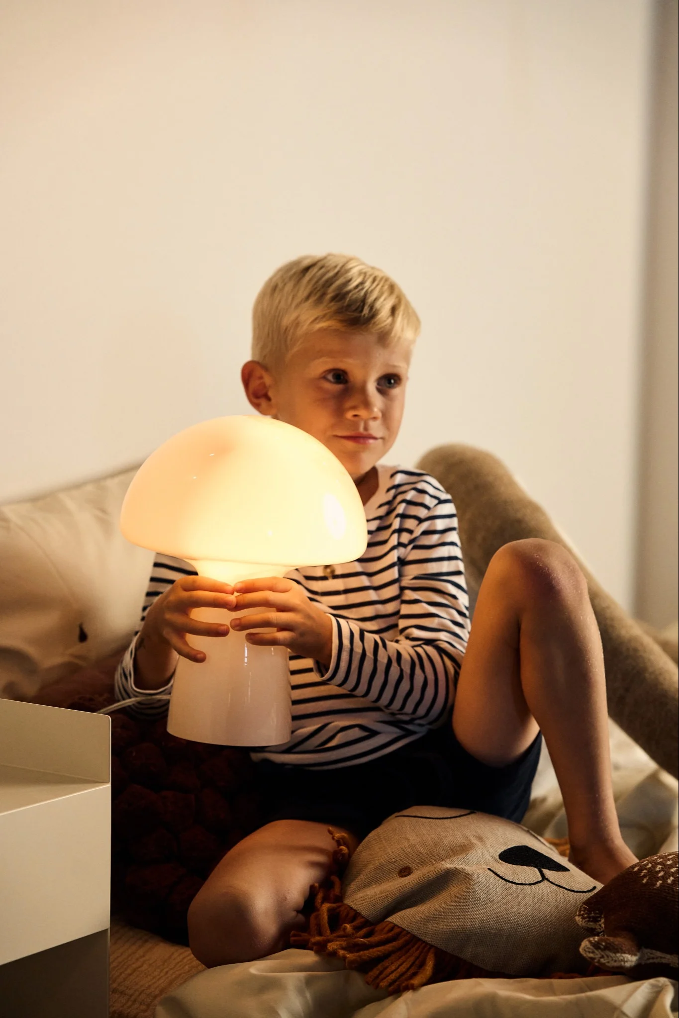 E27 lampe fra Muuto med pære med 2500K på et sidebord.