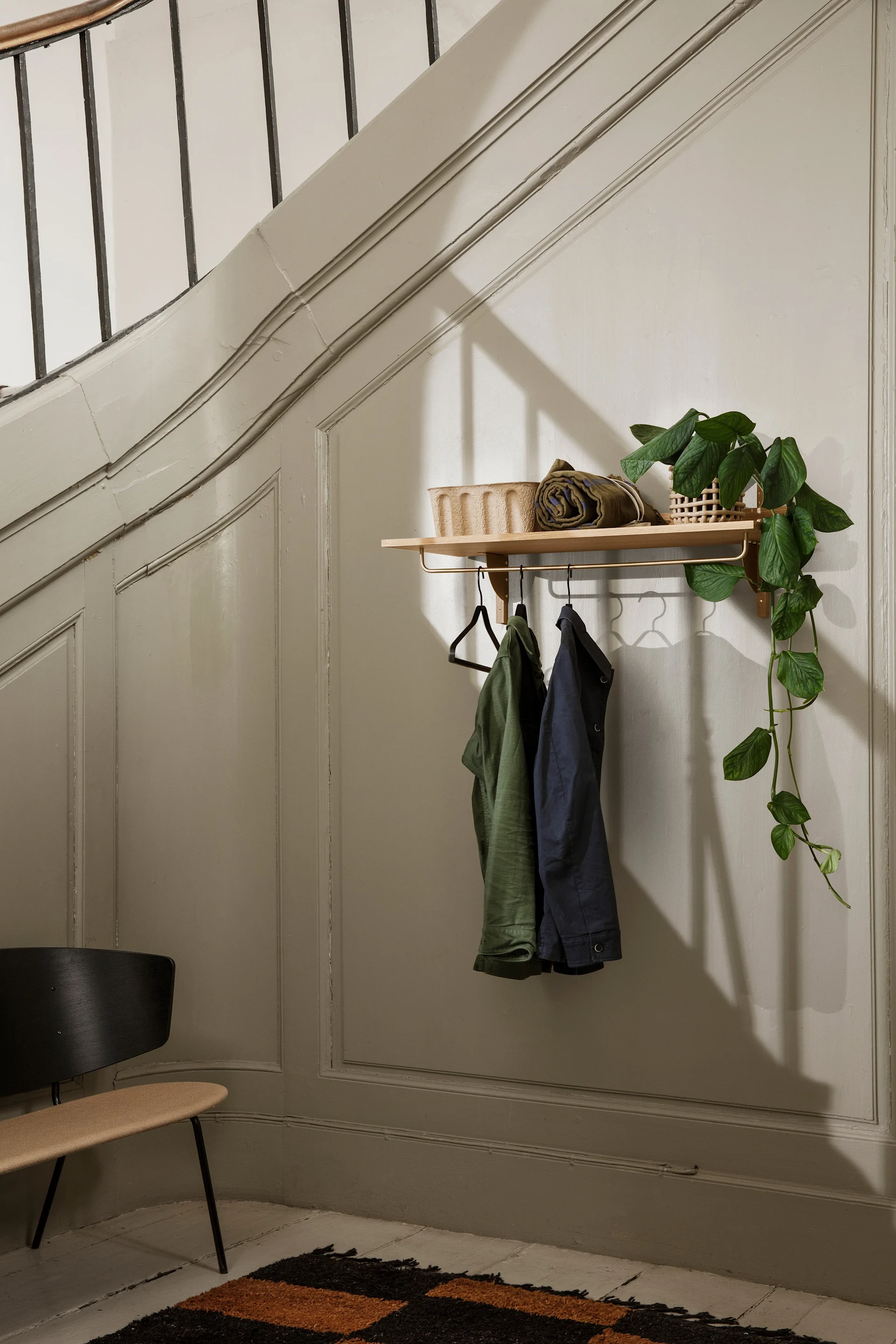 Å ha en åpen garderobe er et tips når du skal innrede en liten entre. Her er en praktisk Sector hylle med stang til å henge kleshengere på fra ferm LIVING.