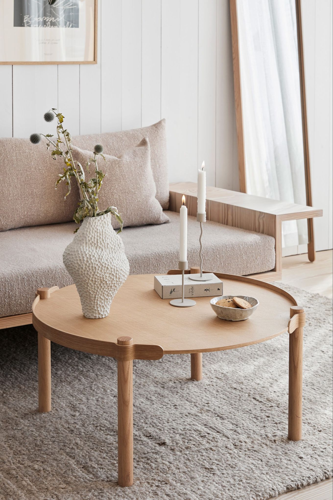 En kremfarget skandinavisk stue med produkter fra Cooee Designs sortiment, inkludert Woody-salongbordet, Isla-vasen og Curve-lysestaken.