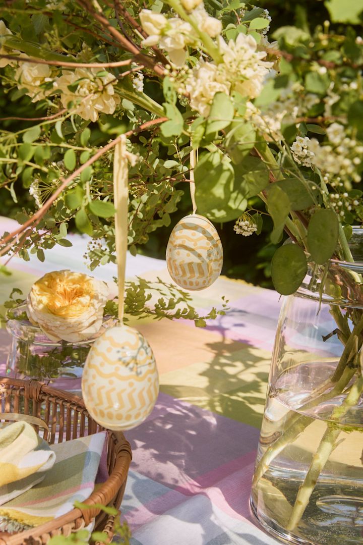 Easter Egg-anhengene fra Lexington henger på et påskeris, plassert utendørs på et fargerikt pyntet bord – en stemningsfull måte å pynte til påske på!