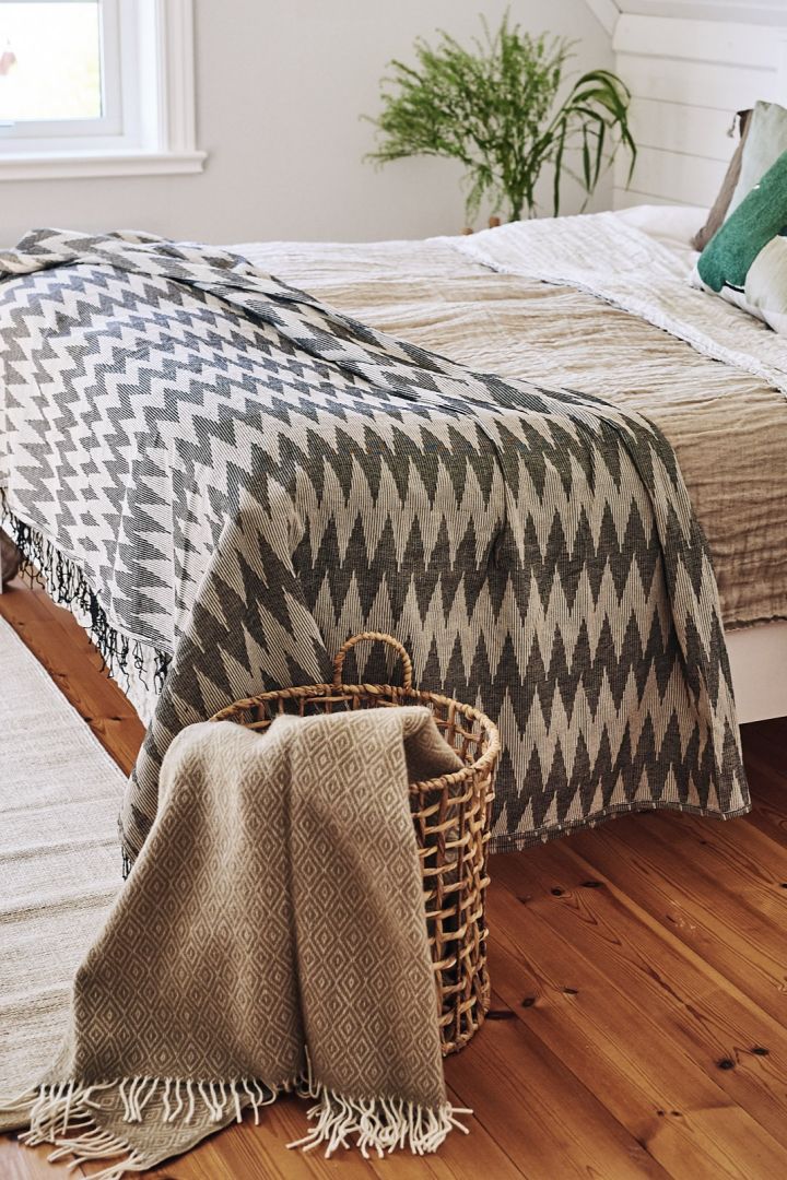 Et soverom innredet i skandinavisk stil med myke tekstiler og puter i beige nyanser er et perfekt sted for frokost på senga.