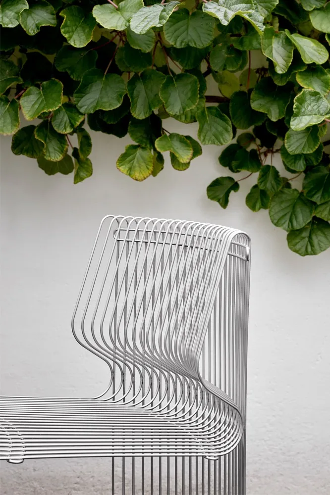 En del av den modulære sofaen Pantonova står utendørs, omkranset av klatreplanter.
