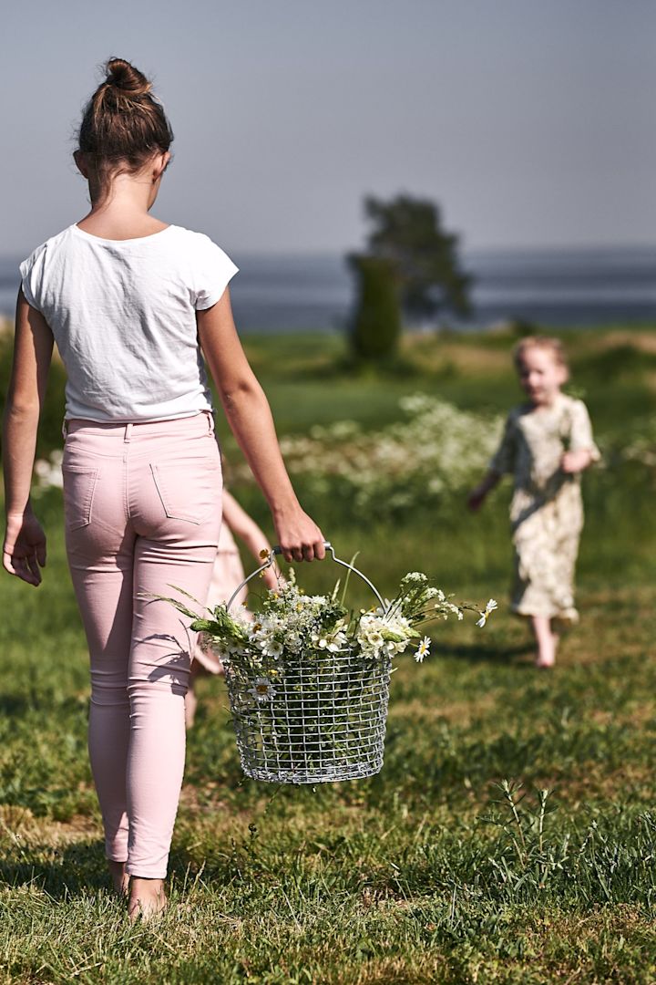 Barna plukker ville blomster på enga for å lage blomsteroppsatser på hagefesten.