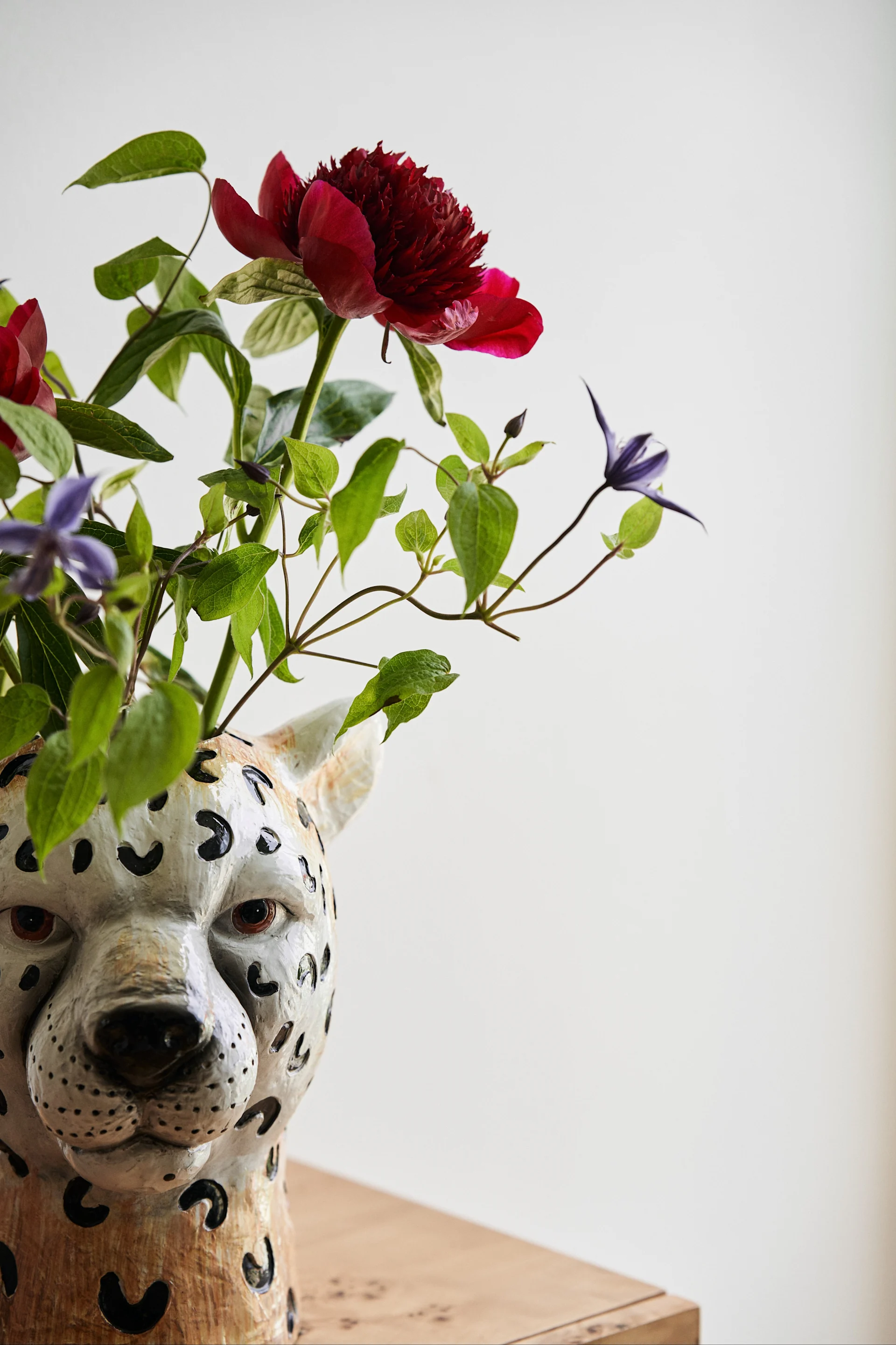 Cheetah-vasen fra Byon var starten på merkets suksesshistorie. Her ser vi en nærbilde av Cheetah-vasen med en bukett blomster i mørkerøde og blå farger.