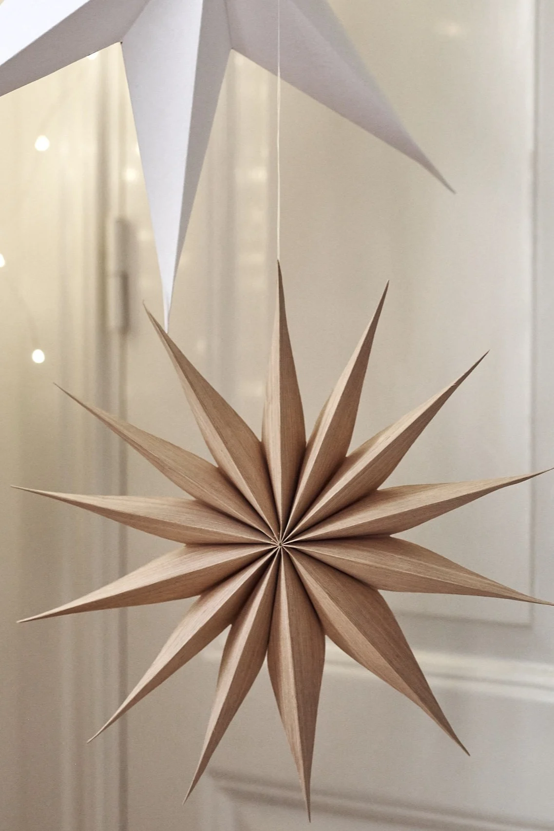 Venok stjerne julepynt fra Broste Copenhagen henger i en stjerneklynge i stua.