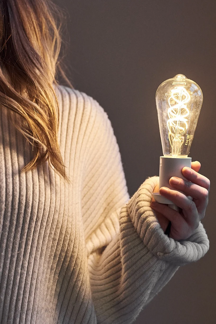 En lyspære i hånden til en kvinne.