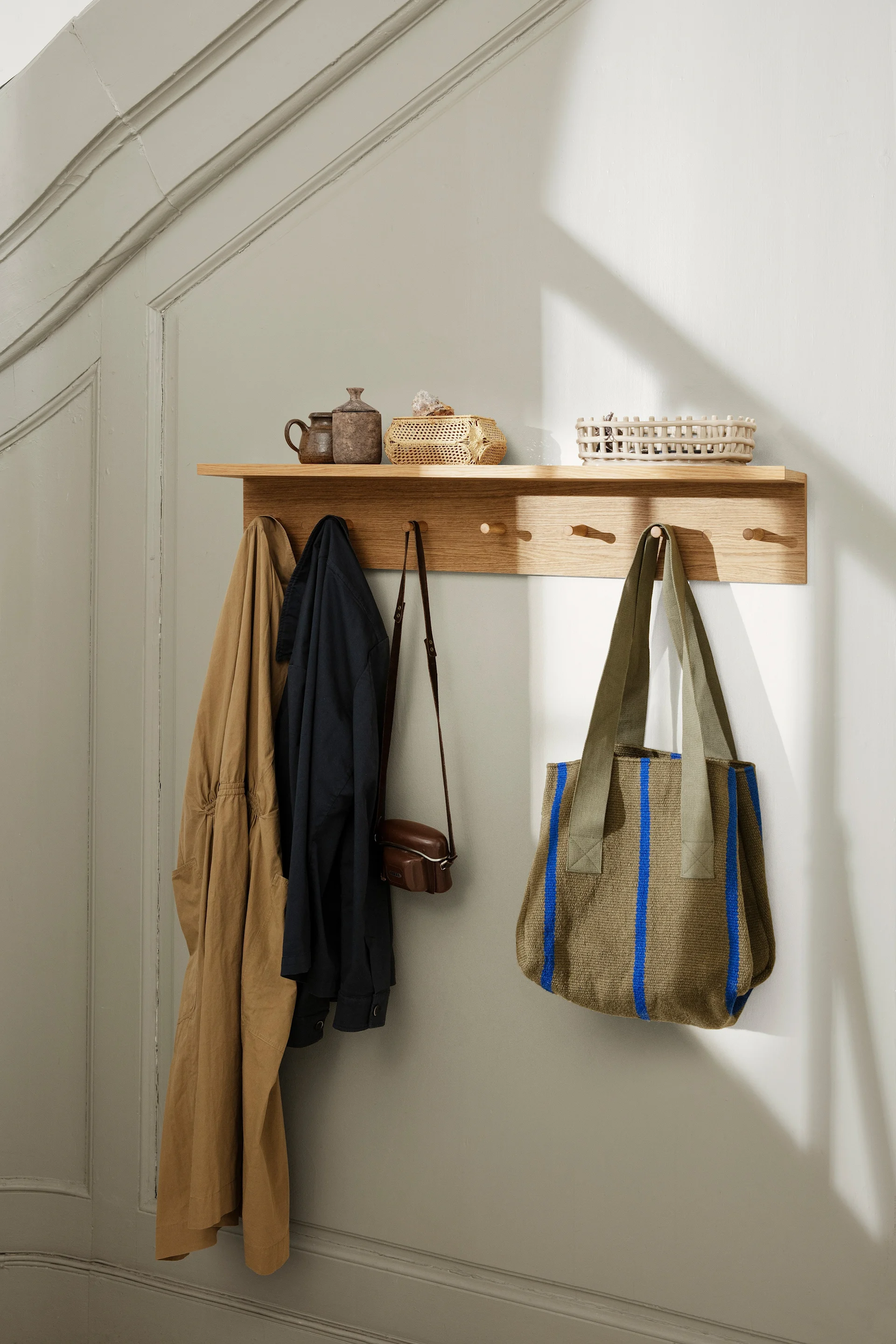 Å ha en åpen garderobe er et tips når du skal innrede en liten entre. Her er en hylle med knottelist fra ferm LIVING som hjelper til med å få orden i entreen.