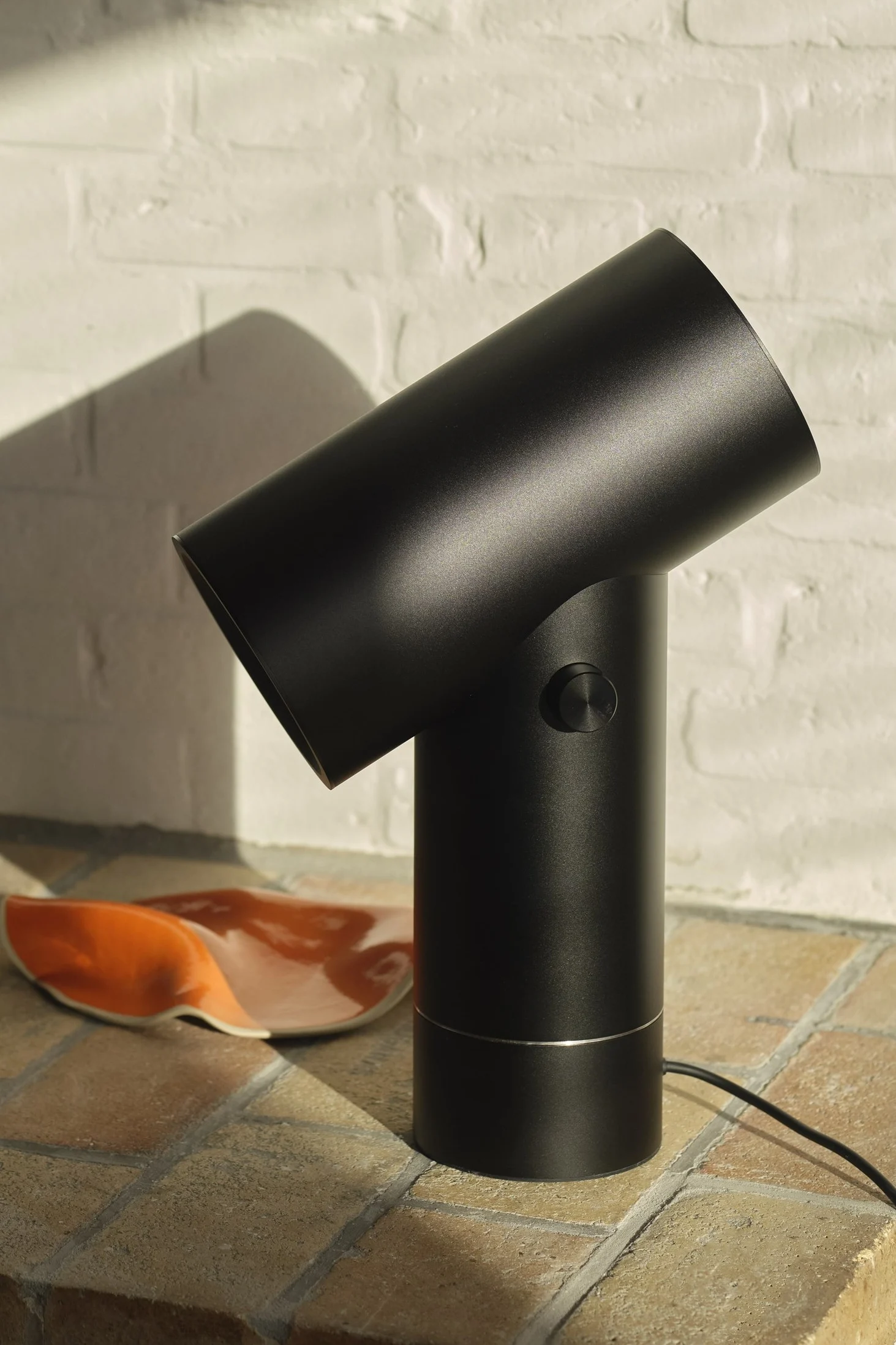 Den svarte Beam-bordlampen fra Muuto i et rom med flislagt interiør.