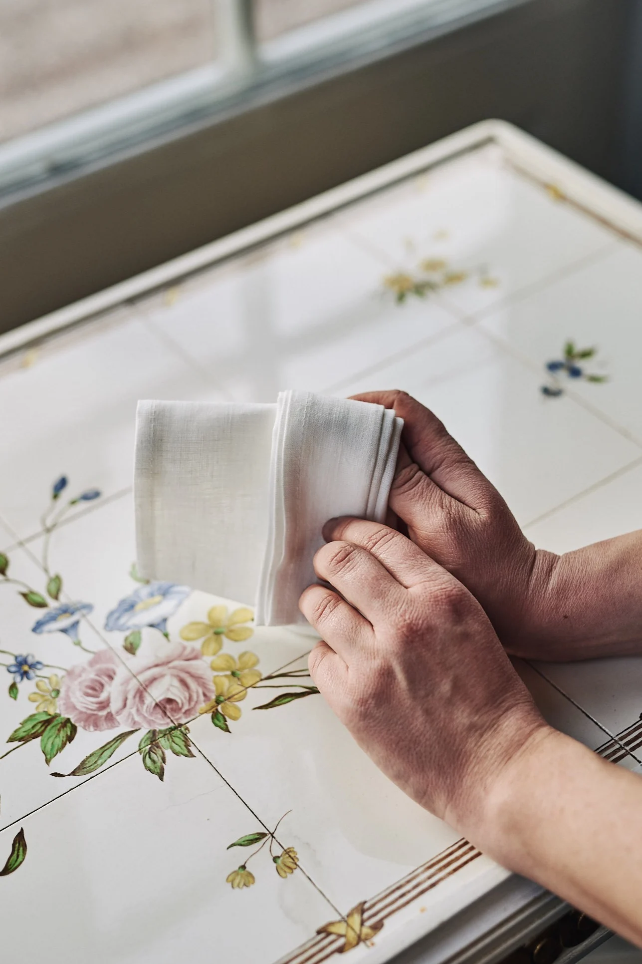 Serviettbretting med hvit linserviett i form av en vifte.