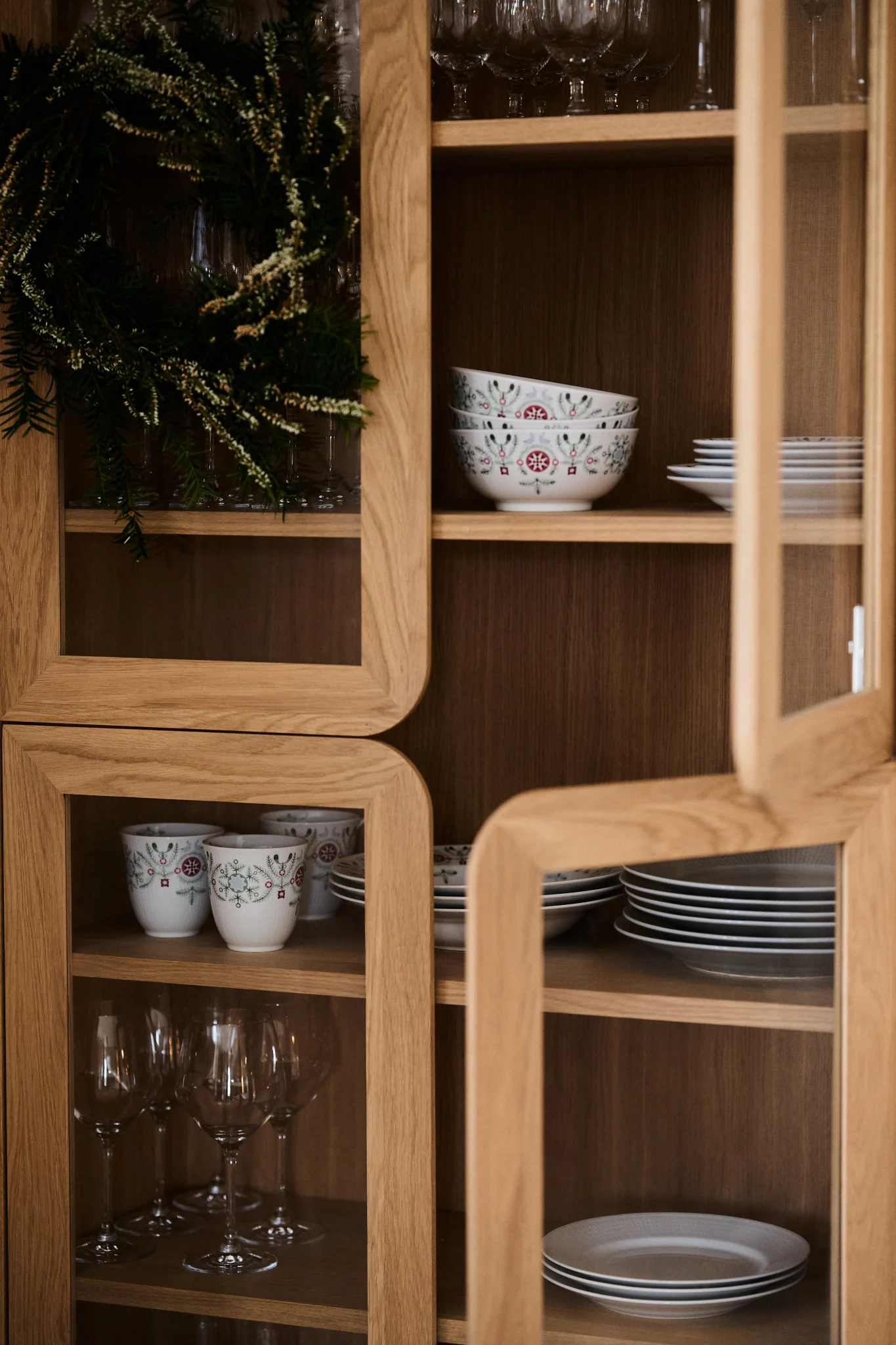 Swedish Grace Winter-kolleksjonen står utstilt i et vitrineskap av tre.