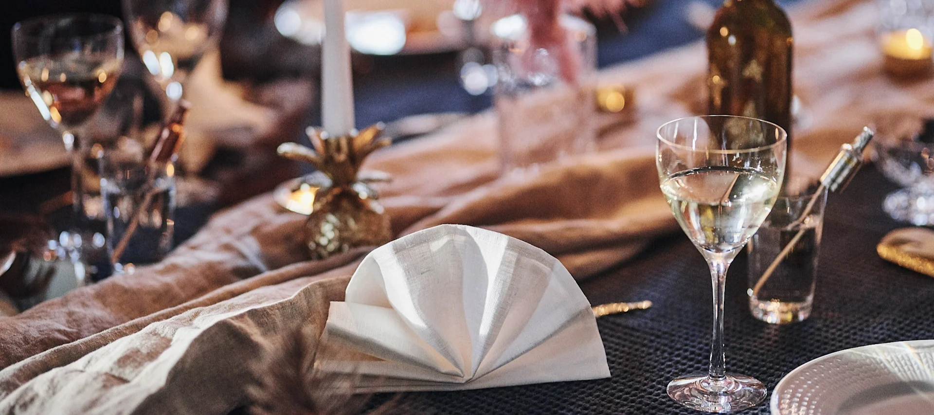 Hvit linserviett brettet til en vifte på et festbord.