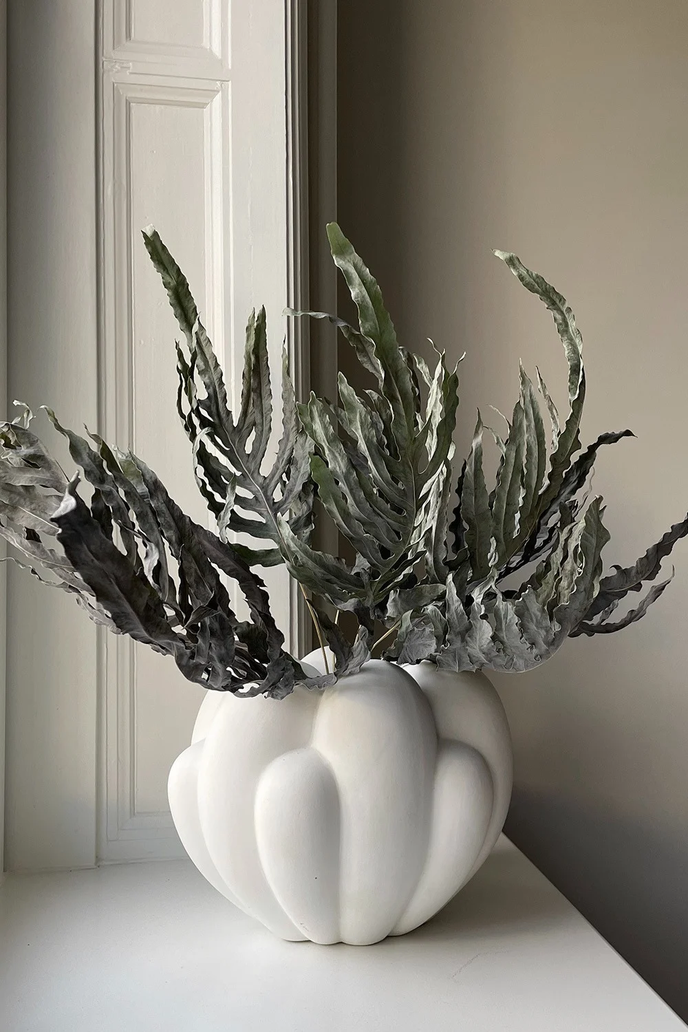En av interiørtrendene våren 2024 er leken minimalisme, der et mer nøytralt fargevalg likevel kan skape et levende hjem ved hjelp av spennende former, teksturer og materialer. Her Bloom-vasen i hvitt fra 101 Copenhagen.