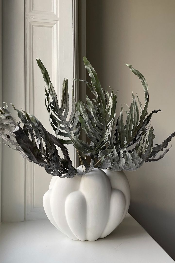 En av interiørtrendene våren 2024 er leken minimalisme, der et mer nøytralt fargevalg likevel kan skape et levende hjem ved hjelp av spennende former, teksturer og materialer. Her Bloom-vasen i hvitt fra 101 Copenhagen.