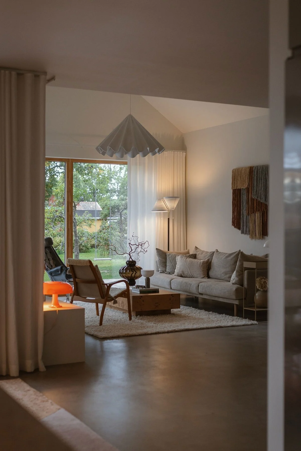 Hjemme i stuen hos Applaudden lyser en oransje lampe som fanger opp interiørtrender 2026.
