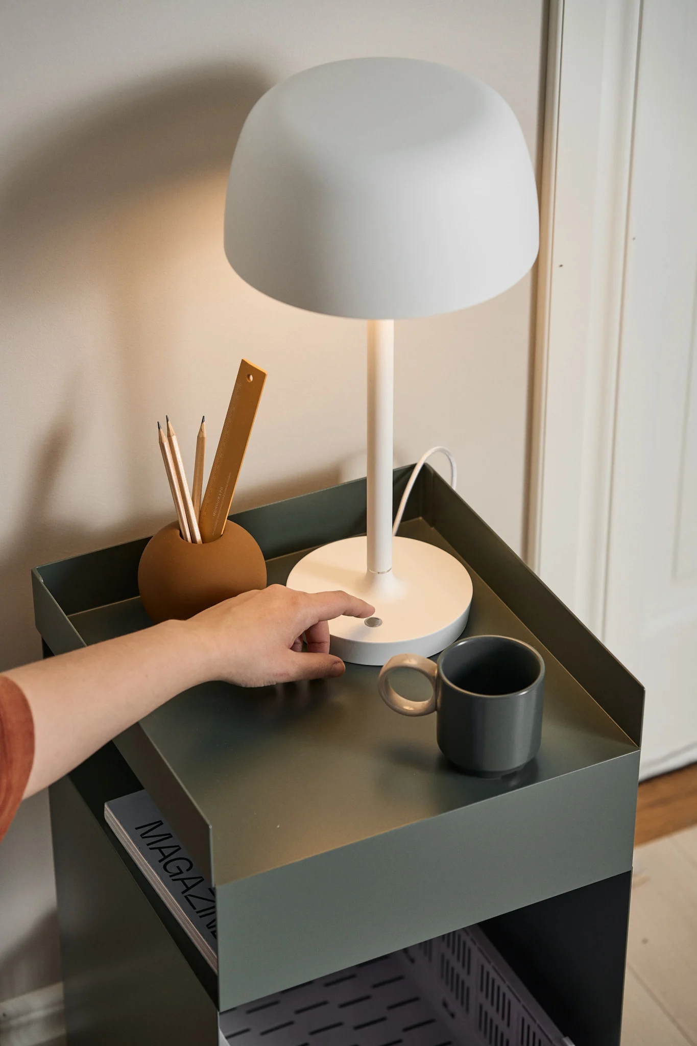 En bordlampe er en perfekt gave til valentinsdag for bokelskere. Her står den hvite Halo-bordlampen fra Scandi Living på et sidebord.