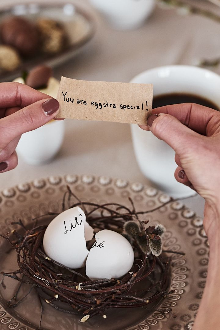 På tallerkenkuvertene til påskebordet blir gjestene ønsket velkommen med et søtt påskeverksted-prosjekt – et utblåst egg med en skjult hilsen, brukt som bordkort!