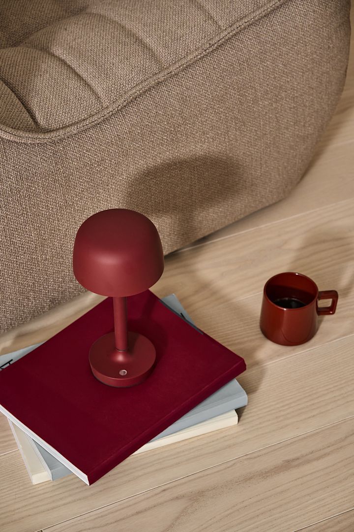 En av de største trendene for 2024 er krom. Her ser du alles favorittlampe, den bærbare bordlampen VP9 Flowerpot i krom, plassert på en krakk ved siden av et glass champagne.