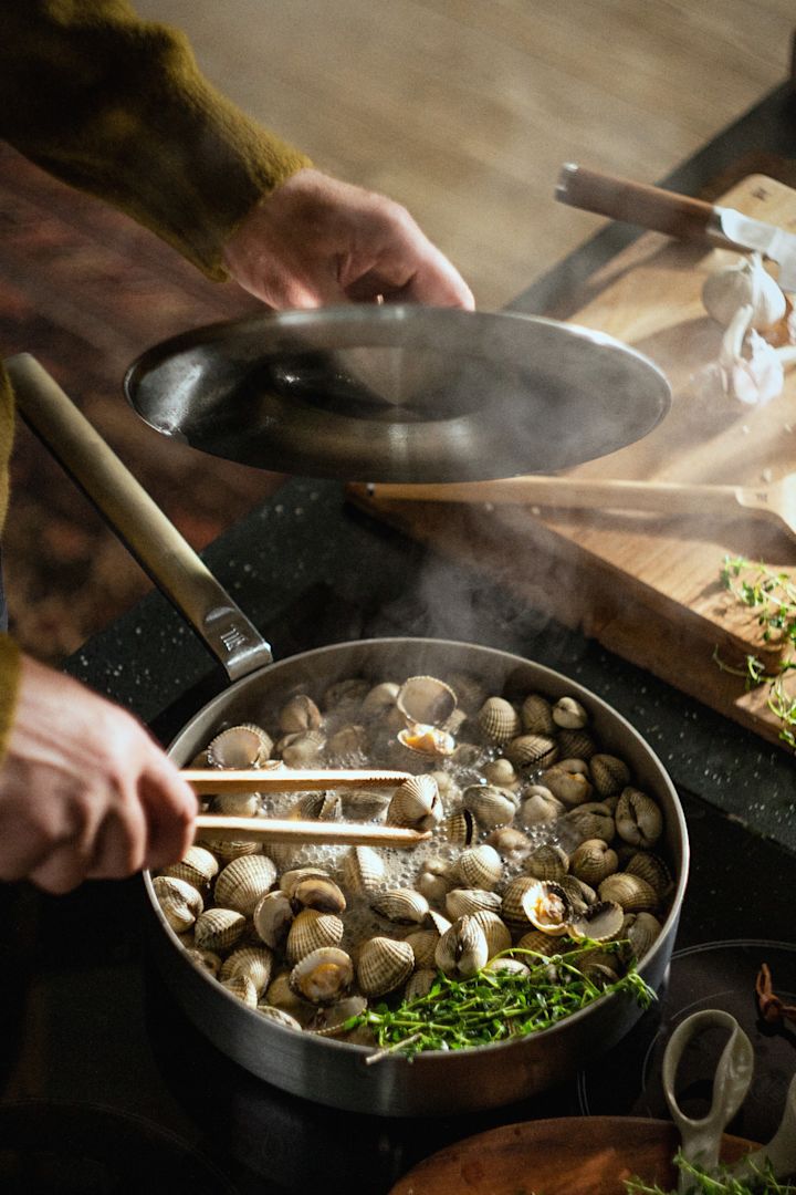 En person tilbereder blåskjell i den rustfrie Norden Steel sauterpannen fra Fiskars.