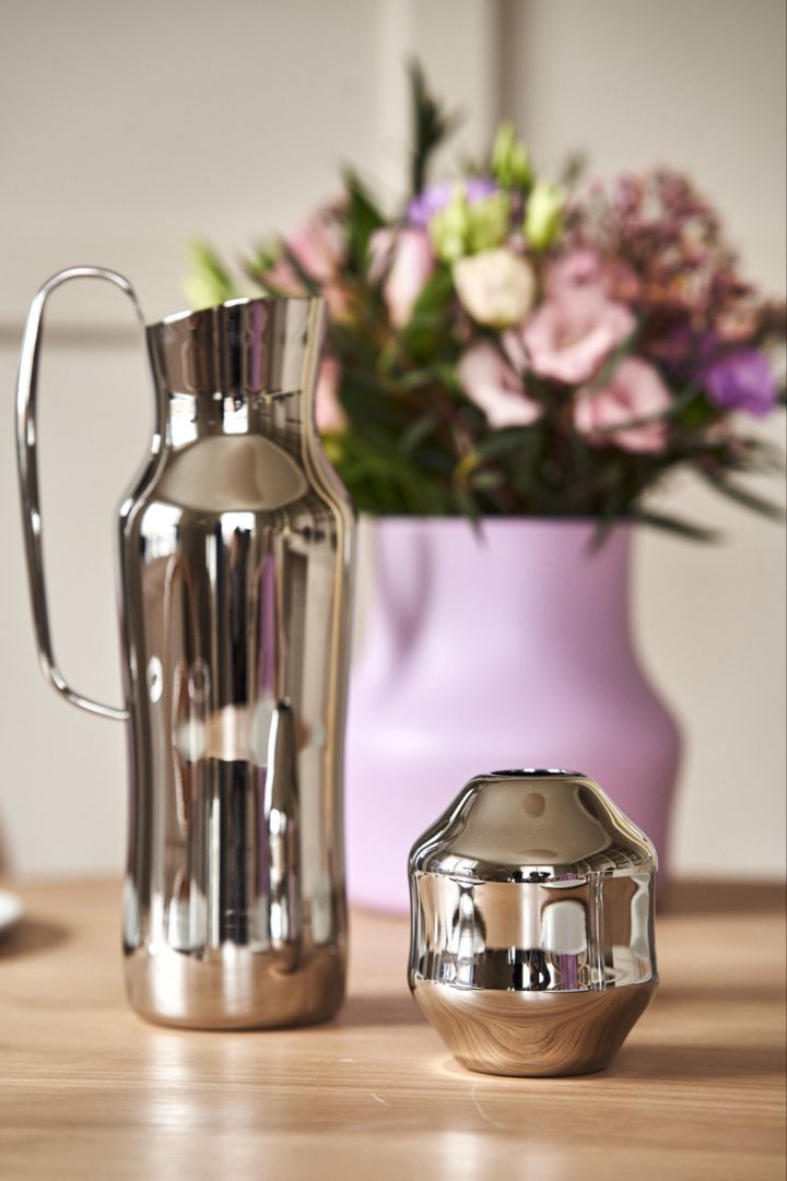 Et nærbilde av den polerte vannkannen i rustfritt stål og mini-Dorotea-vasen designet av Monica Förster for Gense.