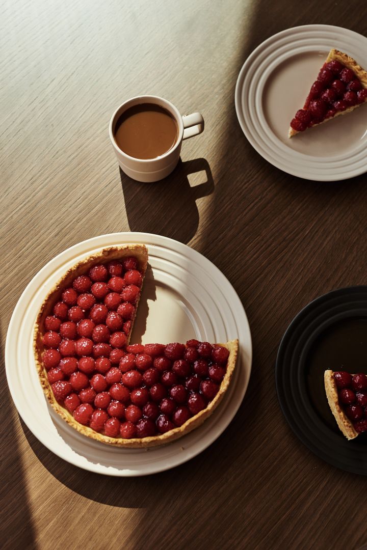 NJRD linjer tallerken i beige med en kirsebærpai og en kopp kaffe. 