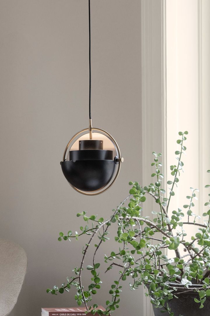 Her ser du Multi Lite pendel fra GUBI hengende i et vindu. En klassisk skandinavisk designlampe.