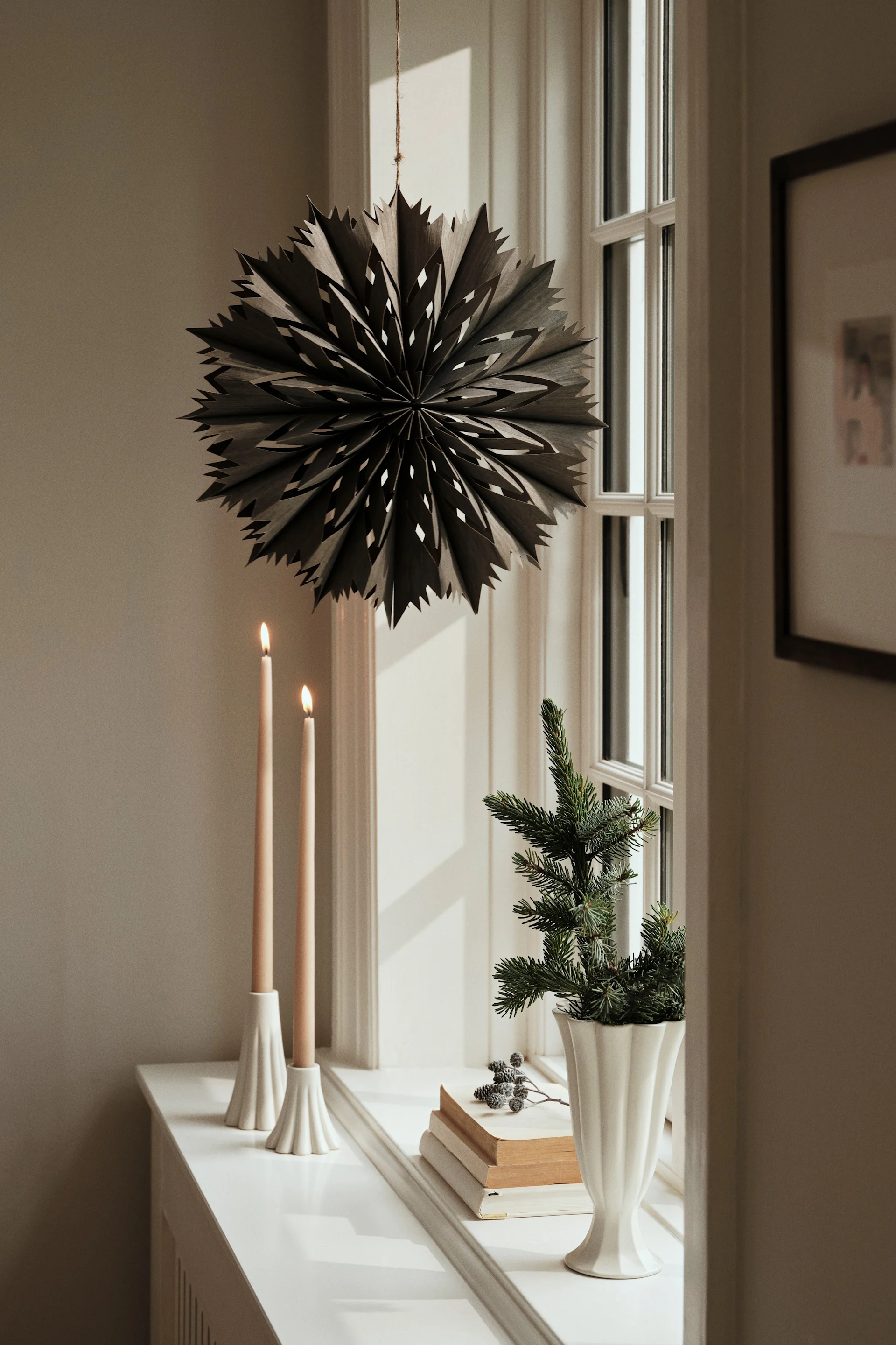 En pyntet vinduskarm med Arc-vasen og lilla blomster.