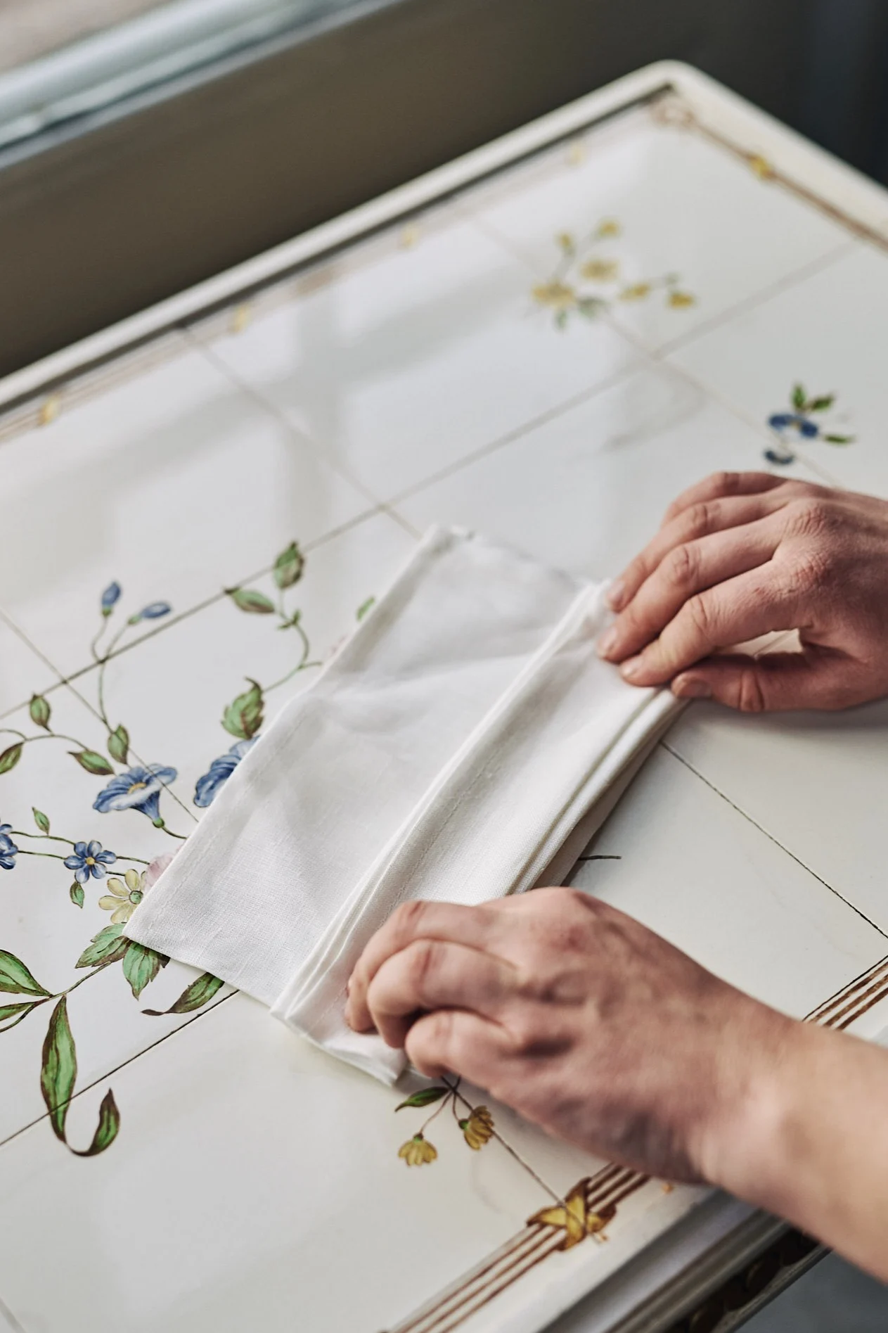 Serviettbretting med hvit linserviett i form av en vifte.