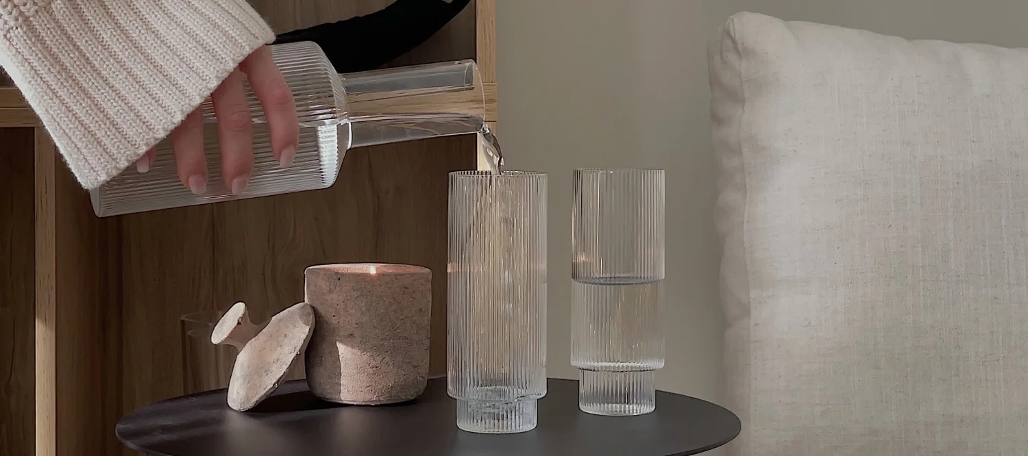 Innredning i riflet glass er en av årets trender. Her fyller influenceren @helenas.hem glasset Ripple med vann fra ferm LIVING Ripple karaffel.