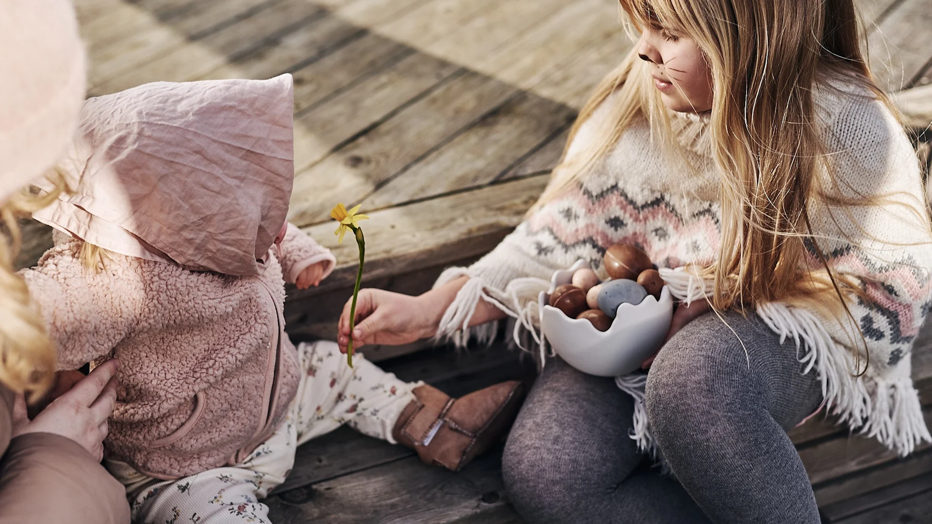 Barn utkledd som påskeharer sitter på trappa og skal dele påskegodteriet som ble vunnet i årets store eggejakt.