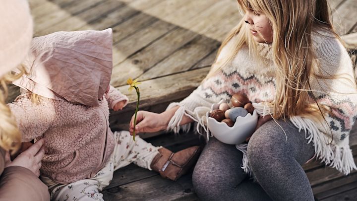 Barn utkledd som påskeharer sitter på trappa og skal dele påskegodteriet som ble vunnet i årets store eggejakt.