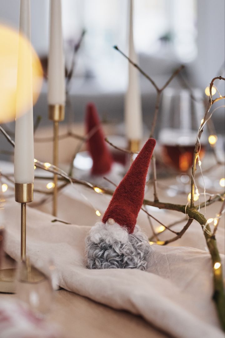 Nisse av ull og lys i messinglysestaker blir vakre dekorasjoner som sprer stemning på julebordet.