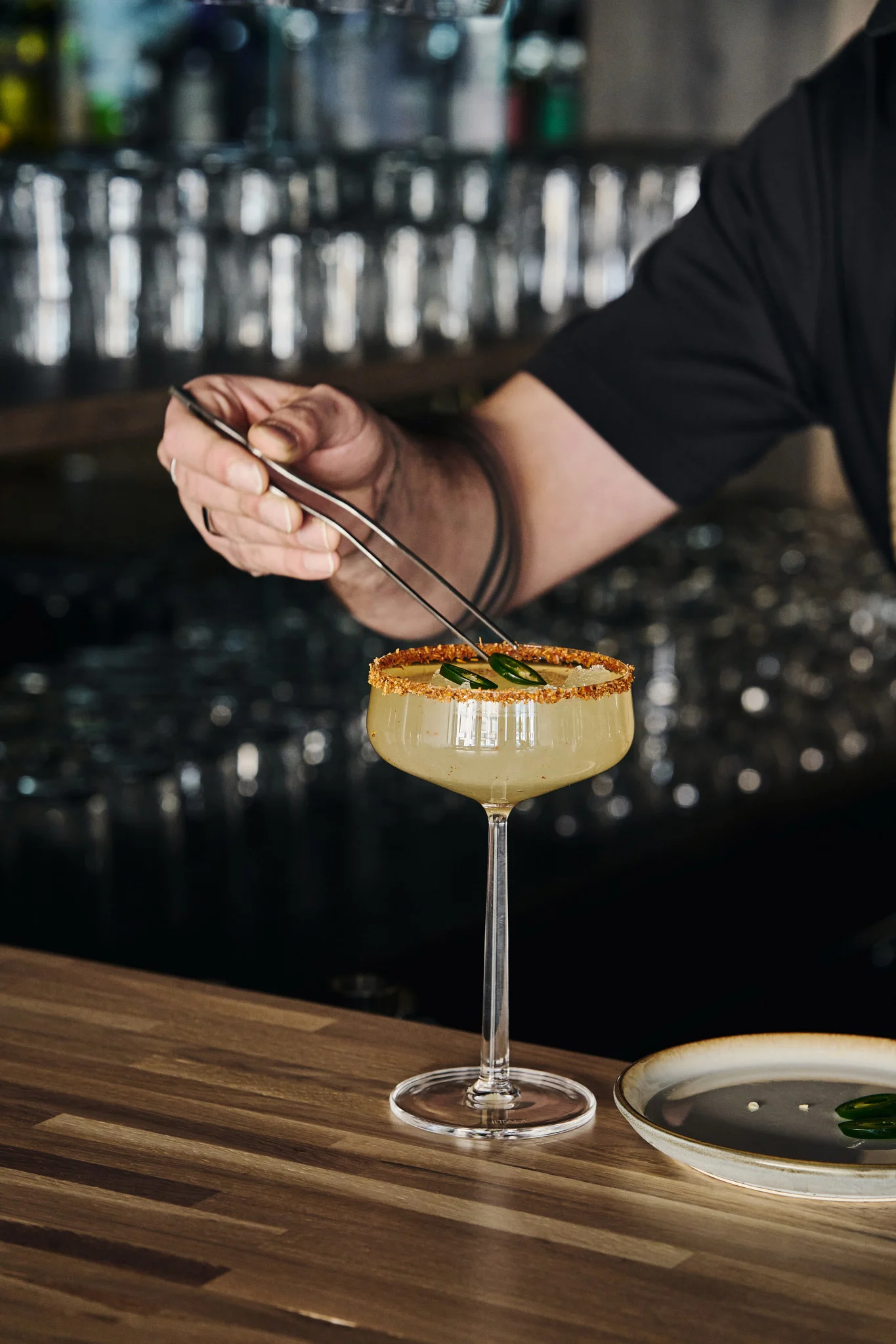 Perfekte til mocktails: Essence cocktailglass fra Iittala med en dekorert drink og jalapeñoskiver servert med tang.